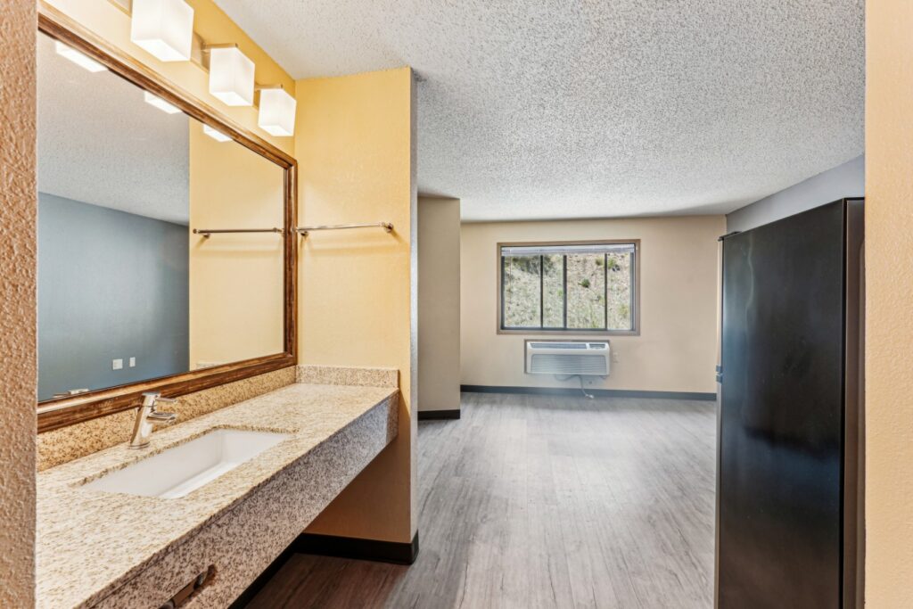 Apartment bathroom sink and oversized mirror at The House Apartments