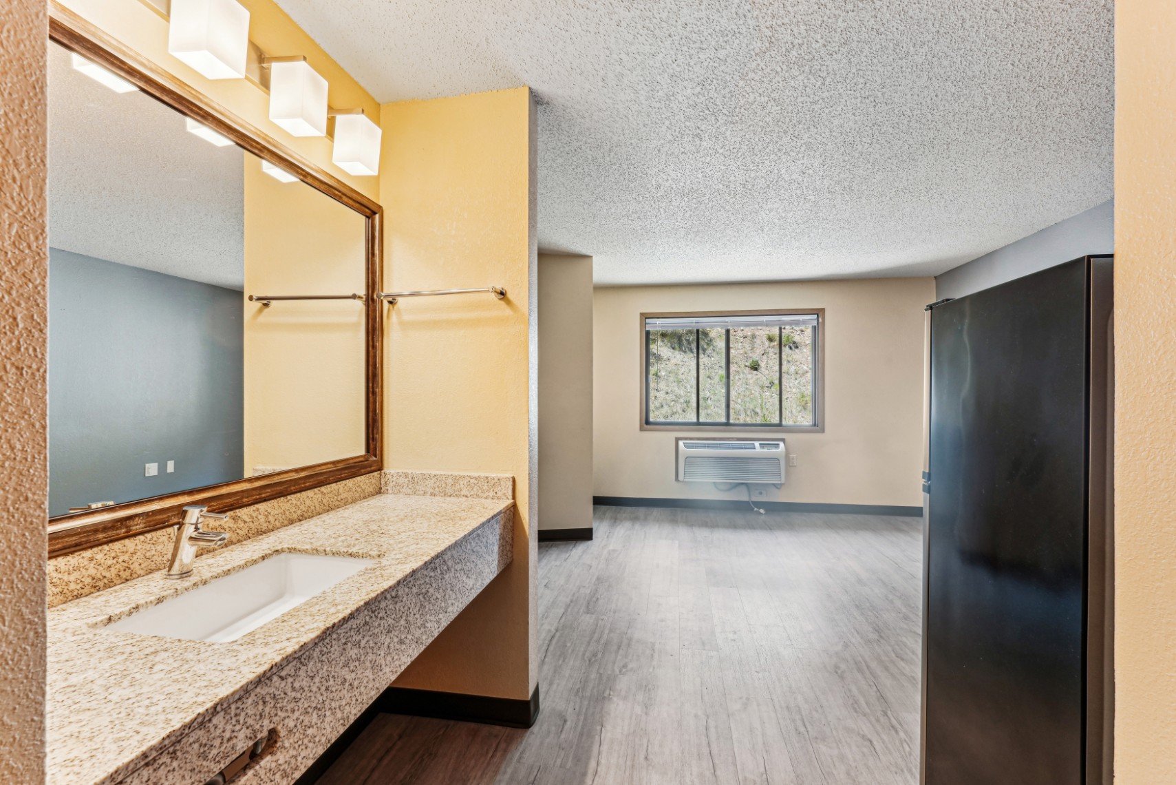 Apartment bathroom sink and oversized mirror at The House Apartments