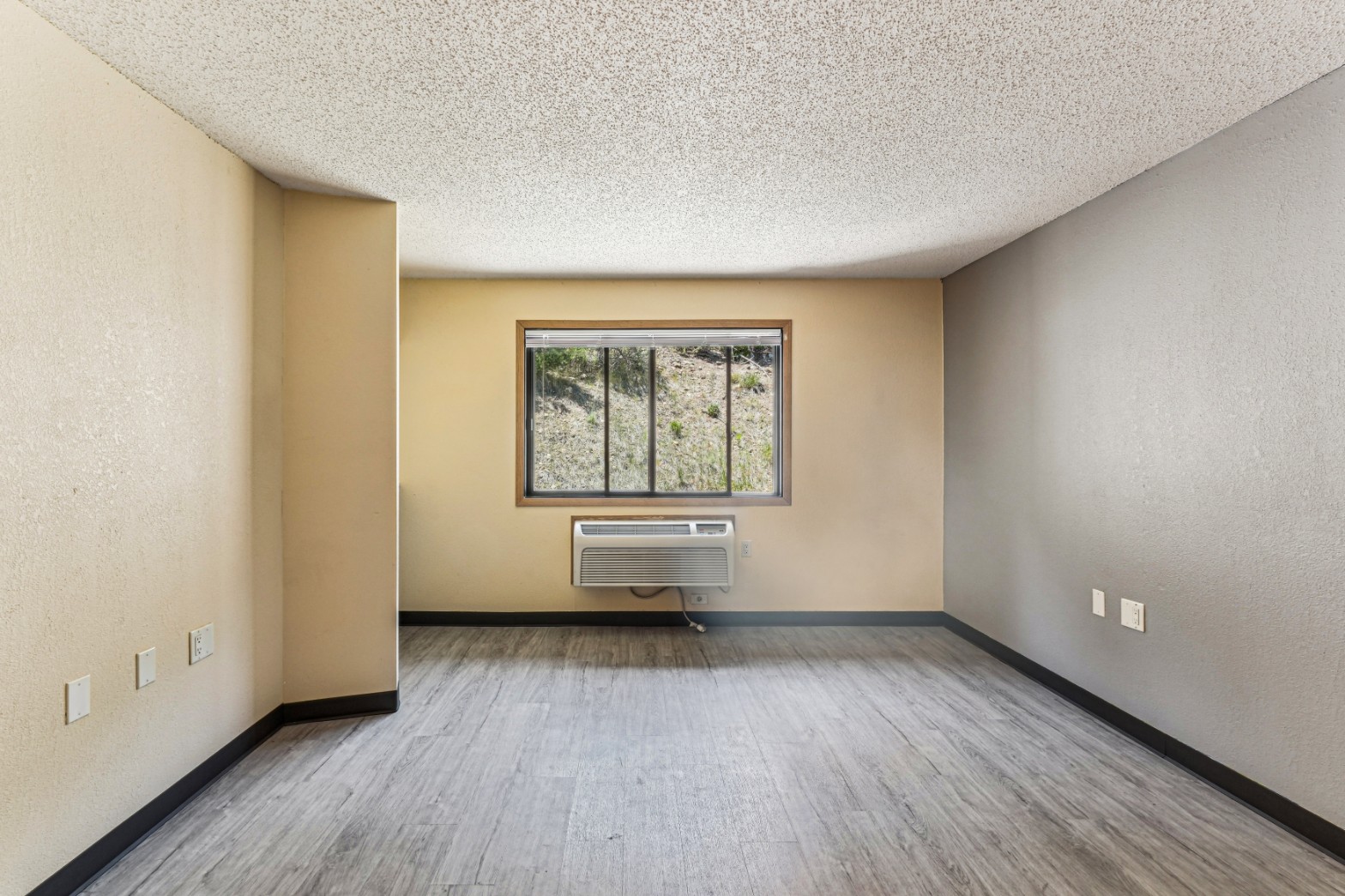 Apartment living area with hardwood style flooring at The House