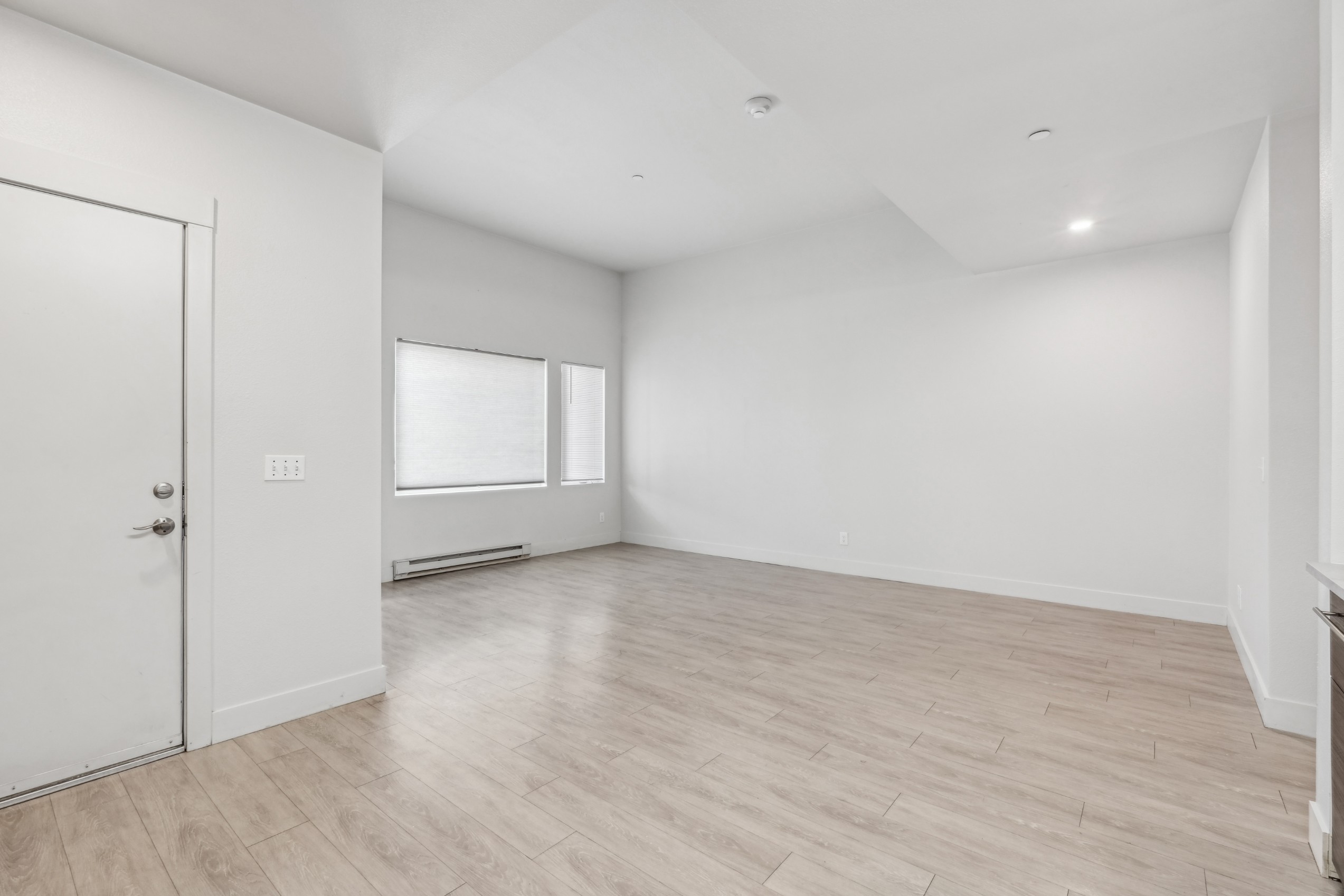 Apartment living room with hardwood style flooring at Red Table Apartments