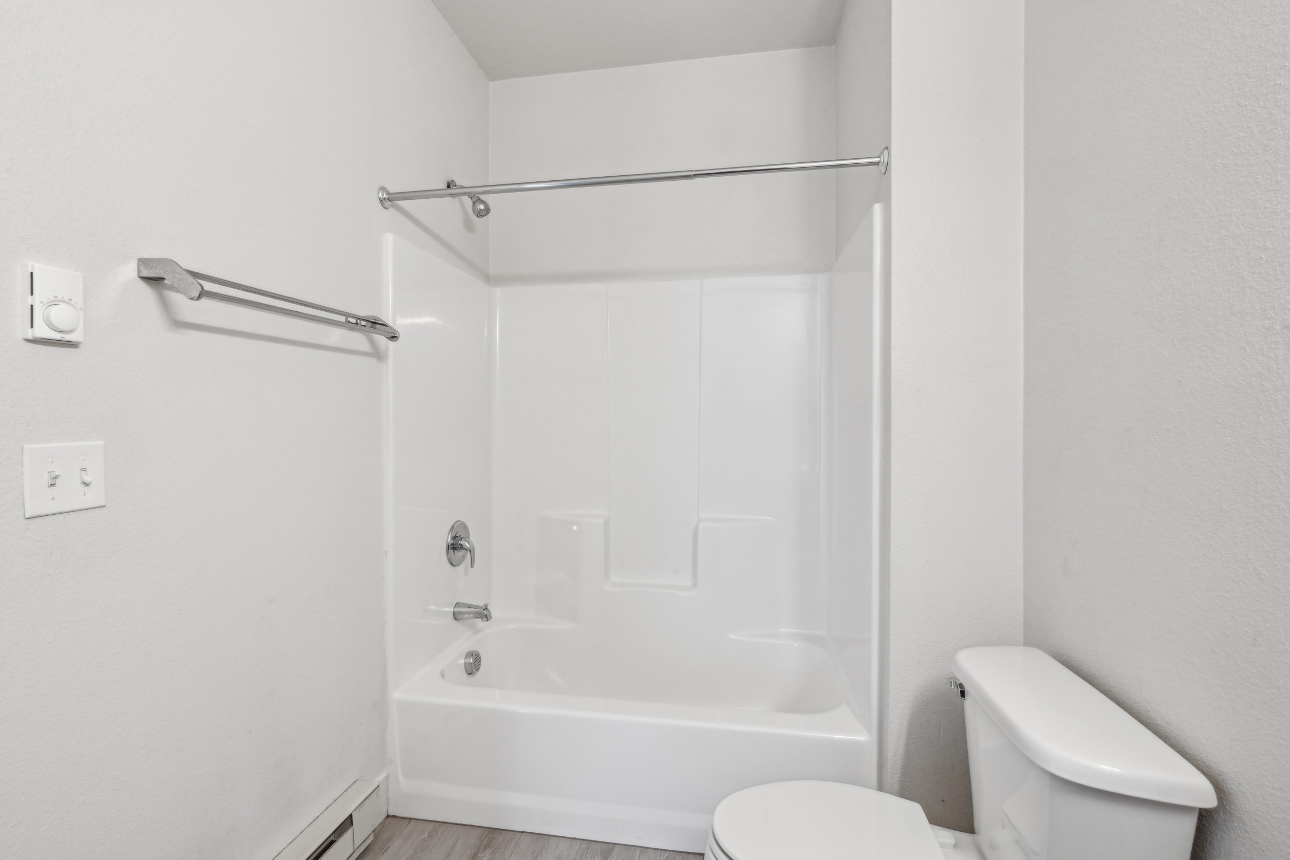 Bathroom with full tub shower combination at Red Table Apartments