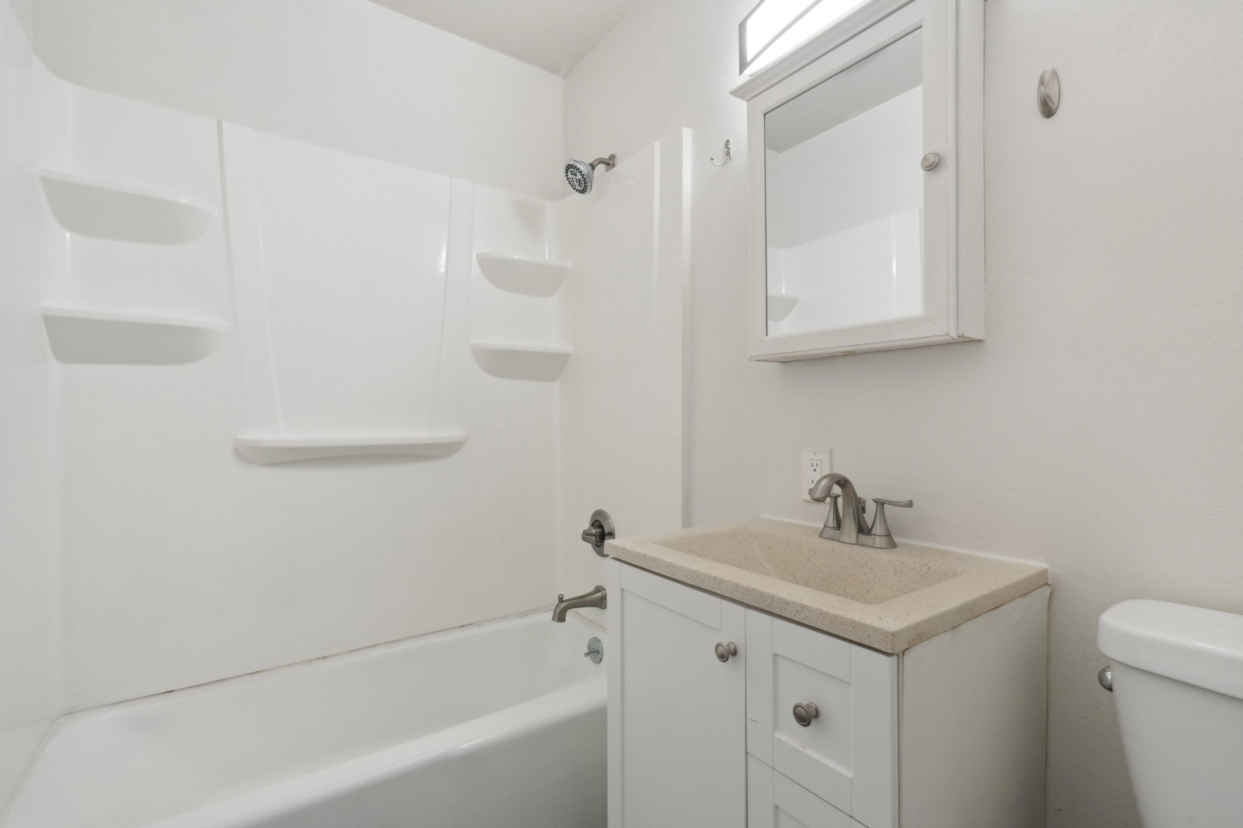 Bathroom with tub shower and vanity storage at Flats on 2nd scaled