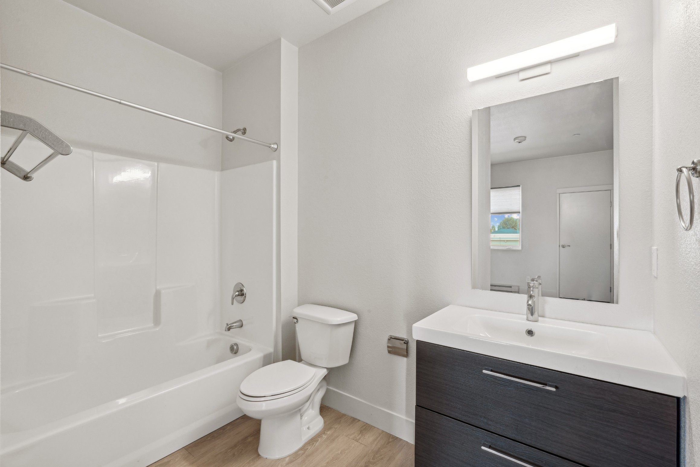Bathroom with vanity and tub shower combination at Red Table Apartments