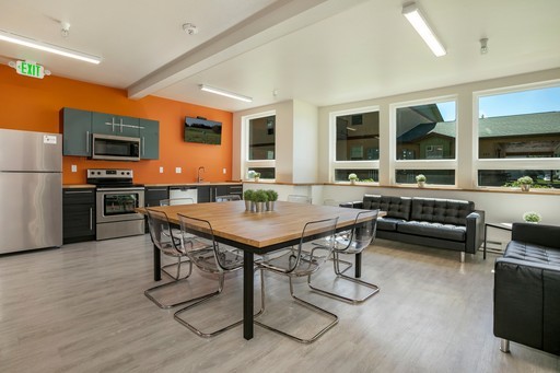 Community room with kitchen and seating at Red Table Apartments