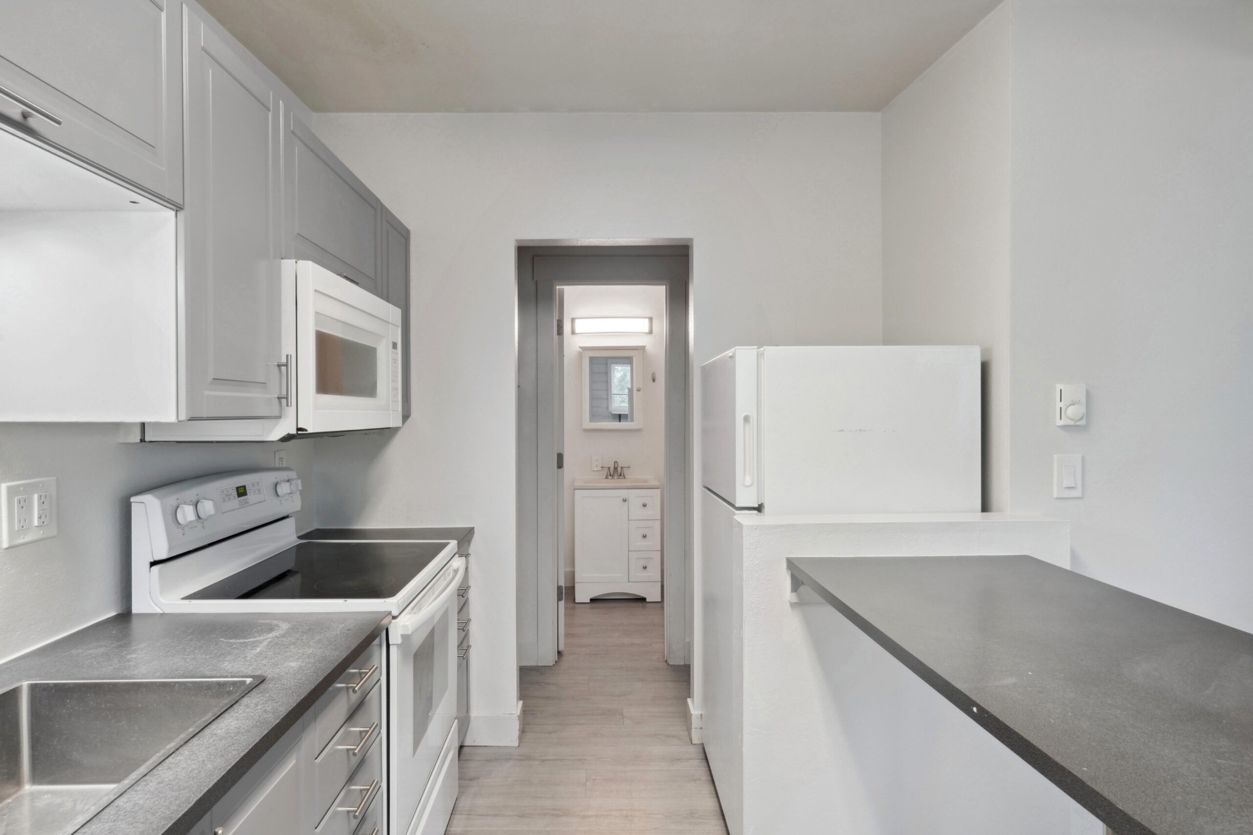 Kitchen and bathroom of a one bedroom apartment at Flats on 2nd scaled