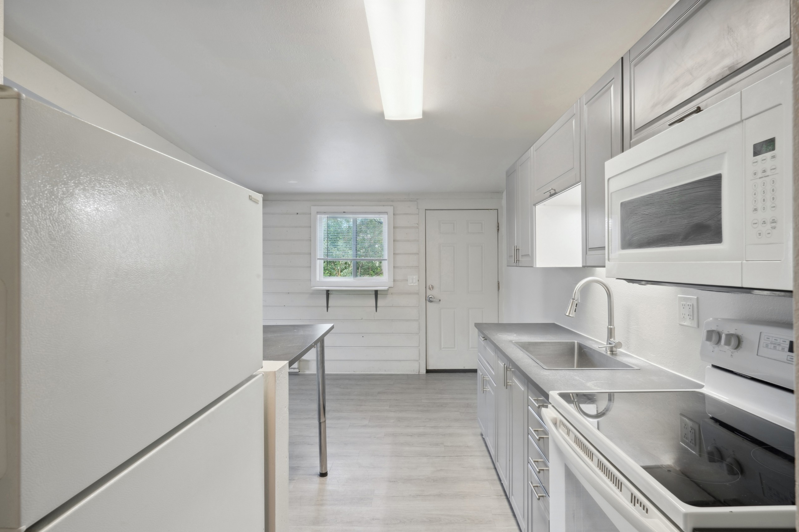 Kitchen with built in microwave full size fridge and electric range at Flats on 2nd