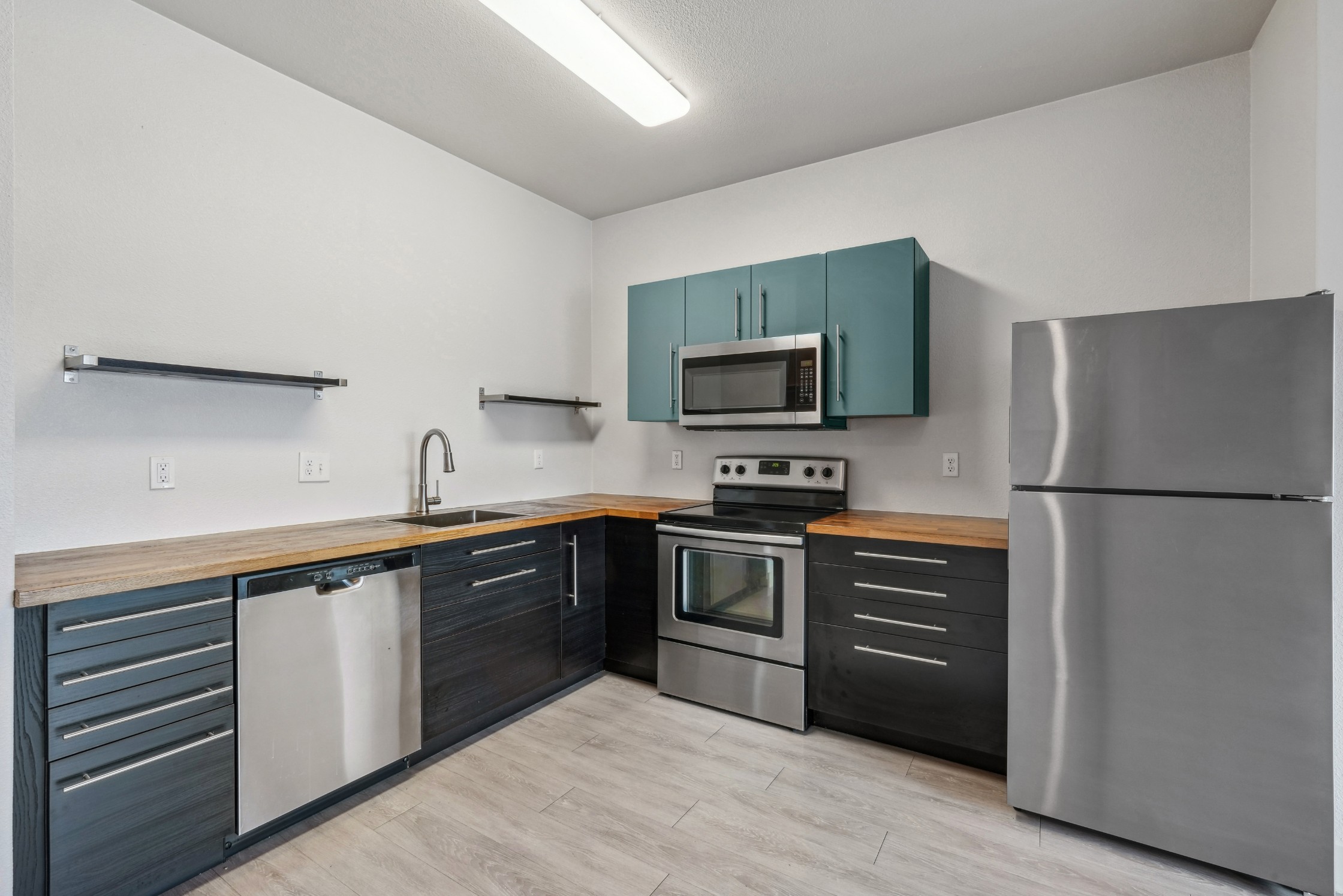 Kitchen with sleek dark cabinetry and stainless steel appliances at Red Table