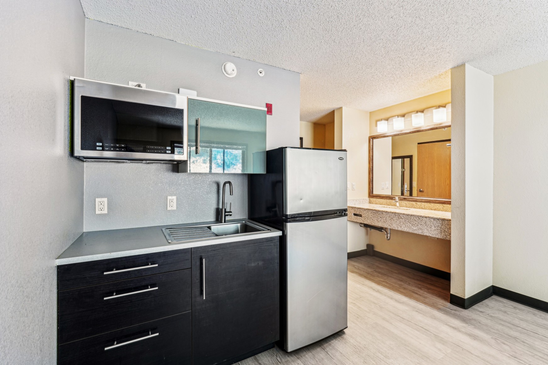 Studio apartment kitchenette with microwave and fridge at The House